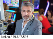handsome young man with slot machine in the casino. Стоковое фото, агентство Ingram Publishing / Фотобанк Лори