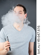portrait of man using a vape. Стоковое фото, агентство Ingram Publishing / Фотобанк Лори