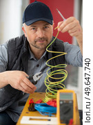 technician putting cables in workshop. Стоковое фото, агентство Ingram Publishing / Фотобанк Лори