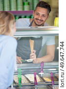 handsome confectioner decorating ice cream with berry in the store. Стоковое фото, агентство Ingram Publishing / Фотобанк Лори
