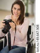 woman in wheelchair at home holding dslr camera. Стоковое фото, агентство Ingram Publishing / Фотобанк Лори
