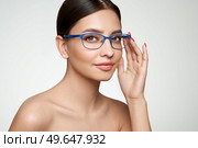 Close up of  young woman with eyeglasses on white background. Vision correction. Poor eyesight. Spectacle frame. Makeup, cosmetics, beauty. Стоковое фото, агентство Ingram Publishing / Фотобанк Лори