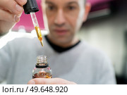 vape shop seller filling liquid in e-cigarette. Стоковое фото, агентство Ingram Publishing / Фотобанк Лори