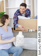 pregnant couple unpacking possessions in their new family home. Стоковое фото, агентство Ingram Publishing / Фотобанк Лори