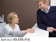 good-looking businessman leaning against the hotel counter. Стоковое фото, агентство Ingram Publishing / Фотобанк Лори