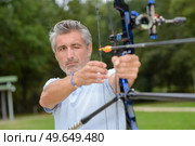 Man aiming bow and arrow. Стоковое фото, агентство Ingram Publishing / Фотобанк Лори