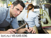 shoemaker hammering on a shoe in workshop. Стоковое фото, агентство Ingram Publishing / Фотобанк Лори