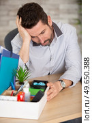 handsome businessman in light modern office with carton box. Стоковое фото, агентство Ingram Publishing / Фотобанк Лори