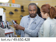 department store seller assisting customer with buying new phone. Стоковое фото, агентство Ingram Publishing / Фотобанк Лори
