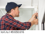 electrician installs alarm on the wall. Стоковое фото, агентство Ingram Publishing / Фотобанк Лори