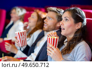 scared friends watching film with popcorn in the cinema. Стоковое фото, агентство Ingram Publishing / Фотобанк Лори