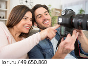 happy couple looking at photos on camera screen. Стоковое фото, агентство Ingram Publishing / Фотобанк Лори