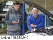 student with instructor repairing a car during apprenticeship. Стоковое фото, агентство Ingram Publishing / Фотобанк Лори