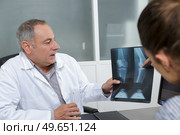 doctor explaining results of knee xray to patient. Стоковое фото, агентство Ingram Publishing / Фотобанк Лори