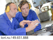 teacher showing student how to operate machine. Стоковое фото, агентство Ingram Publishing / Фотобанк Лори