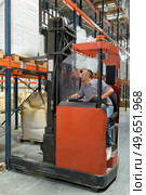 warehouse worker using fork truck to load pallet on racking. Стоковое фото, агентство Ingram Publishing / Фотобанк Лори