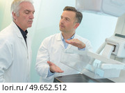 radiation technologist explaining the feature of the machine. Стоковое фото, агентство Ingram Publishing / Фотобанк Лори