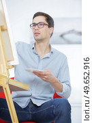 male artist paints on an easel in the workshop. Стоковое фото, агентство Ingram Publishing / Фотобанк Лори