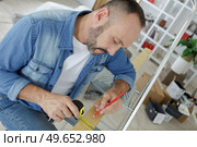 a man carpenter use measuring tape measure wood. Стоковое фото, агентство Ingram Publishing / Фотобанк Лори