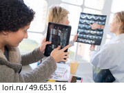 medical staff looking at xrays and tablet screen. Стоковое фото, агентство Ingram Publishing / Фотобанк Лори