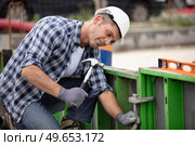 builder worker with hammer at construction site. Стоковое фото, агентство Ingram Publishing / Фотобанк Лори