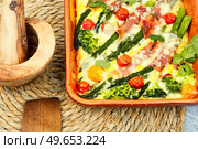 Asparagus wrapped in bacon, baked with tomatoes, broccoli and cheese. Homemade delicious casserole. Casserole with asparagus and bacon in baking dish. Стоковое фото, агентство Ingram Publishing / Фотобанк Лори