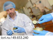 close up of hands calibrating cans. Стоковое фото, агентство Ingram Publishing / Фотобанк Лори