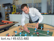 shop assistant fixing a football table. Стоковое фото, агентство Ingram Publishing / Фотобанк Лори