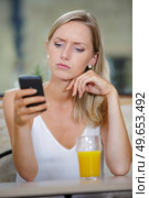 woman with dismay expression looking at her cellphone. Стоковое фото, агентство Ingram Publishing / Фотобанк Лори
