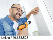man drilling the wall with drill perforator. Стоковое фото, агентство Ingram Publishing / Фотобанк Лори