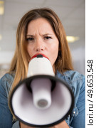 frowning woman speaking through a loud speaker. Стоковое фото, агентство Ingram Publishing / Фотобанк Лори