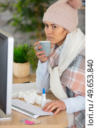 poorly woman wearing woolly hat using computer. Стоковое фото, агентство Ingram Publishing / Фотобанк Лори