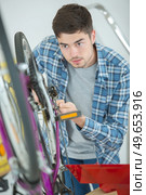 a man changing the bikes breaks. Стоковое фото, агентство Ingram Publishing / Фотобанк Лори