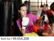 Teen girls fight with feet and hands, using all strength, courage. Kickboxing and boxing lesson. Стоковое фото, фотограф Яков Филимонов / Фотобанк Лори