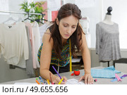 woman tailor working on a clothing sewing stitching measuring fa. Стоковое фото, агентство Ingram Publishing / Фотобанк Лори