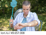 woman on camping holiday tries to catch a mosquito. Стоковое фото, агентство Ingram Publishing / Фотобанк Лори