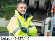 young municipal garbage collector near garbage truck. Стоковое фото, агентство Ingram Publishing / Фотобанк Лори