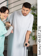 kind female nurse helping male patient on ctutches. Стоковое фото, агентство Ingram Publishing / Фотобанк Лори