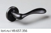 Black door handle showcasing sleek design and craftsmanship. Черная дверная ручка, демонстрирующая элегантный дизайн и мастерство исполнения. Стоковое AI-изображение, AI-художник Katsiaryna Repich / Фотобанк Лори