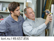 man measuring width of building materials. Стоковое фото, агентство Ingram Publishing / Фотобанк Лори