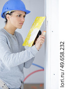 working woman plastering walls inside the house. Стоковое фото, агентство Ingram Publishing / Фотобанк Лори