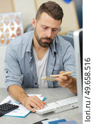 a young man checking references. Стоковое фото, агентство Ingram Publishing / Фотобанк Лори