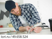 plumber installing sink siphon in domestic bathroom. Стоковое фото, агентство Ingram Publishing / Фотобанк Лори