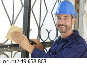 a handyman sanding a fence. Стоковое фото, агентство Ingram Publishing / Фотобанк Лори