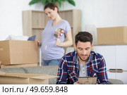 man looking at a frame while unpacking. Стоковое фото, агентство Ingram Publishing / Фотобанк Лори