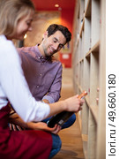 sommelier in wine store giving recommendation for bottle of wine. Стоковое фото, агентство Ingram Publishing / Фотобанк Лори