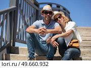 portrait of happy couple sitting together on staircase in embrace. Стоковое фото, агентство Ingram Publishing / Фотобанк Лори