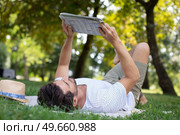 man reading a newspaper while sitting on a green meadow. Стоковое фото, агентство Ingram Publishing / Фотобанк Лори