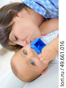 happy mother with baby lying on bed at home. Стоковое фото, агентство Ingram Publishing / Фотобанк Лори