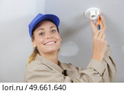 female electrician mounting light fitting. Стоковое фото, агентство Ingram Publishing / Фотобанк Лори